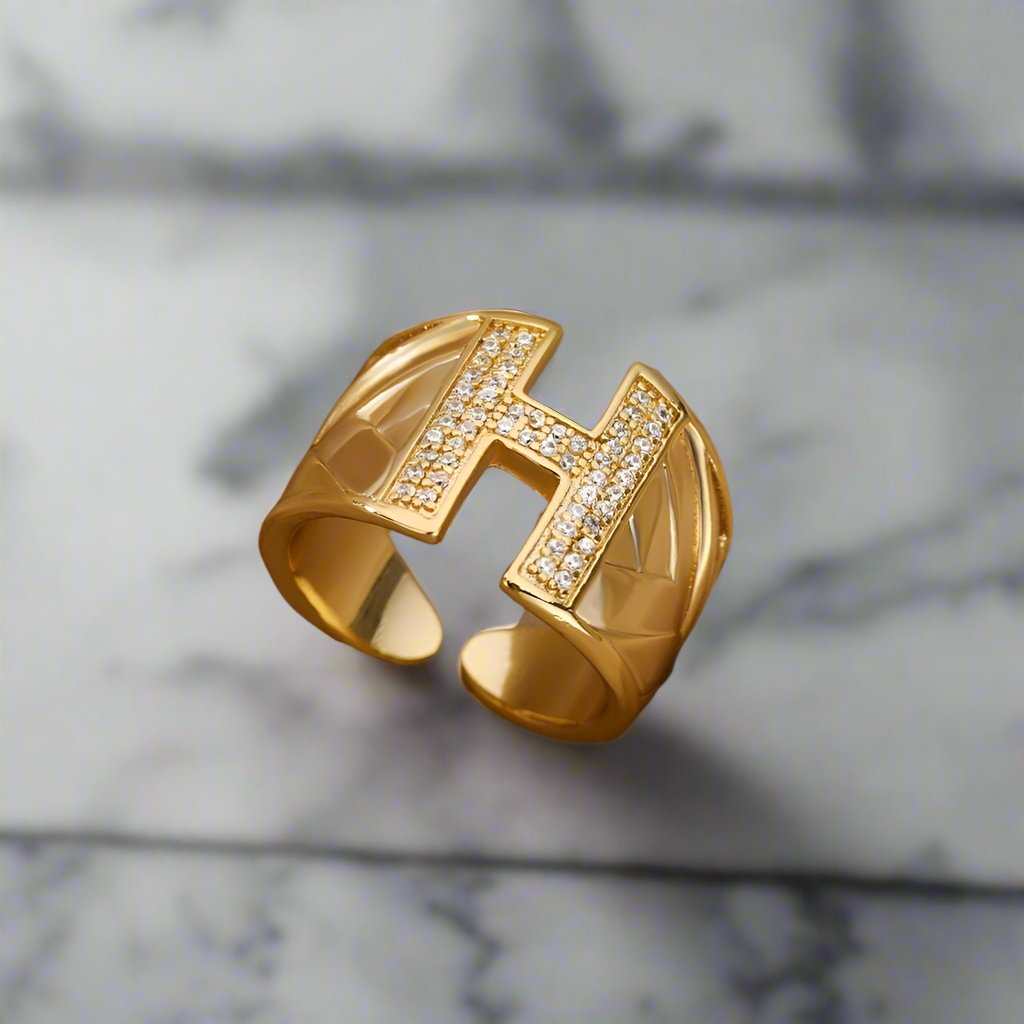 Gold YourLetter Chunky Ring with adjustable signet design displaying letter 'H'.