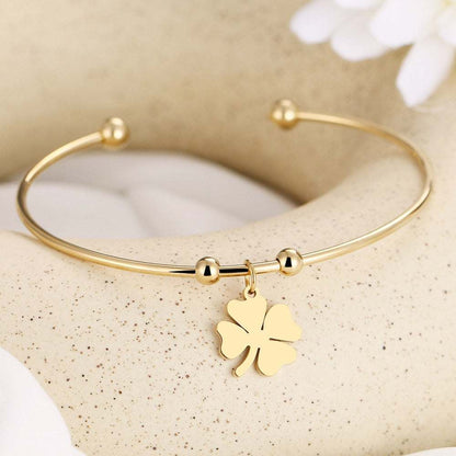 Four Leaf Clover Open Bracelet in gold and silver tones on display.