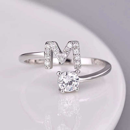 Adjustable ring with letter 'M' and gem stud in silver.