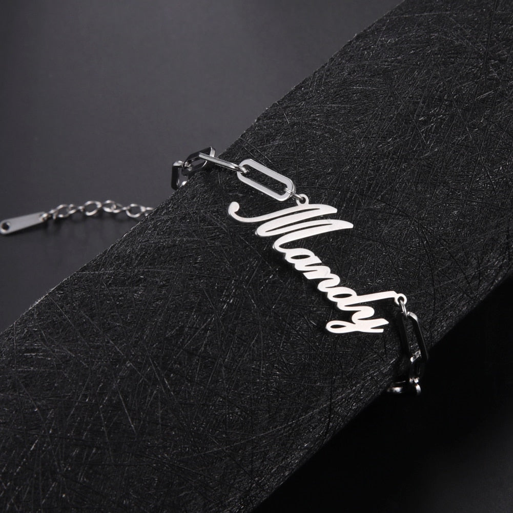 Chain links name bracelet in metal alloy with customizable inscription, available in gold or silver.