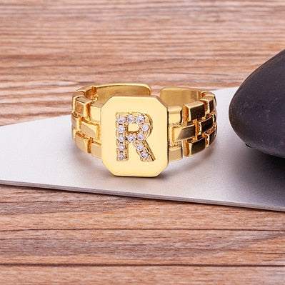 Yourletter Chunky Embossed Ring with imitation gems on wooden surface.