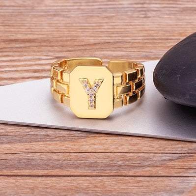 Yourletter Chunky Embossed Ring with imitation gems on wooden surface.