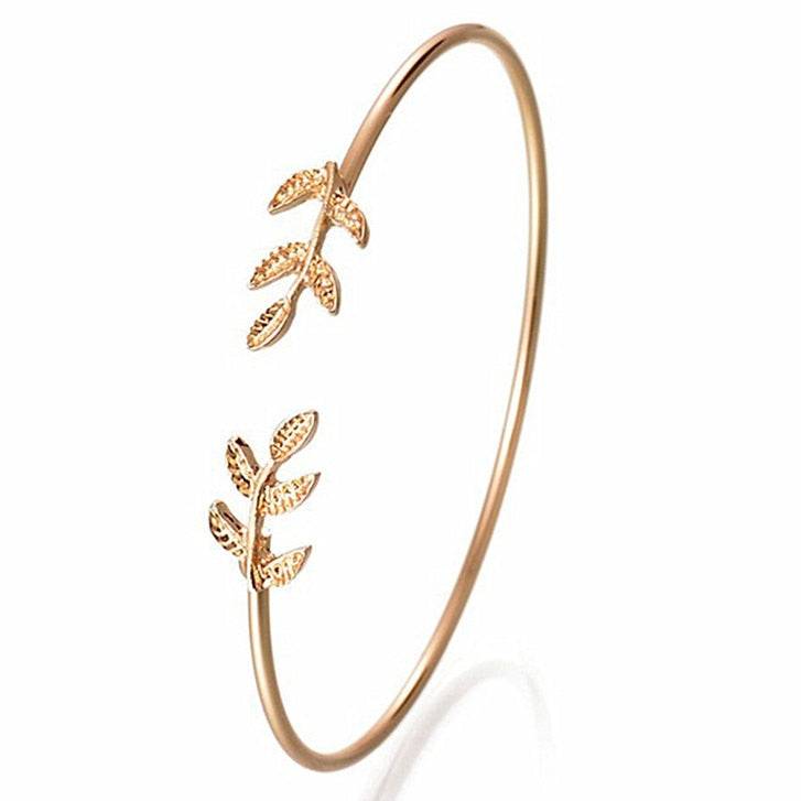 Gold adjustable leaf cuff bracelet with elegant design.