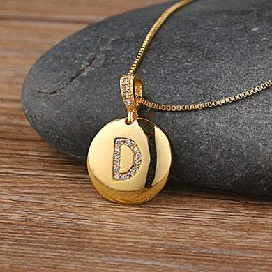 Custom gold YourLetter jeweled pendant chain with gemstone-encrusted letter.