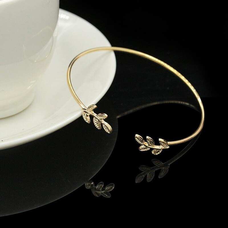 Leaf Cuff Bracelet in gold with elegant leaf design next to a white cup.