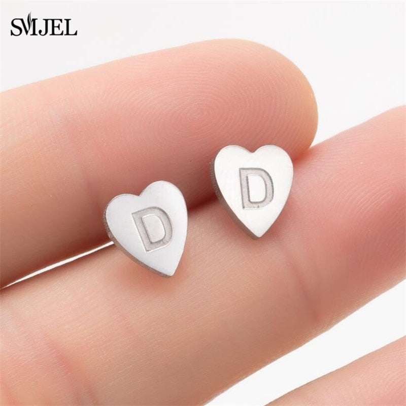 Heart-shaped stud earrings with personalized initial in silver.