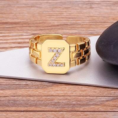 Gold letter-embossed chunky ring with sparkling imitation gems.