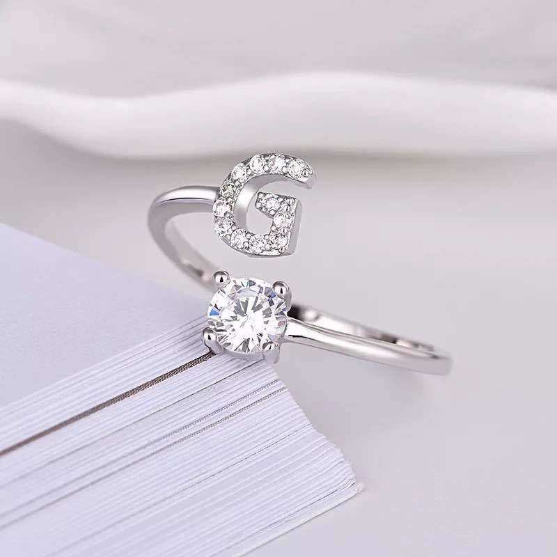 Adjustable letter ring with gem stud in silver, featuring the letter 'G'.