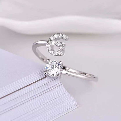 Adjustable letter ring with gem stud in silver, featuring the letter 'G'.