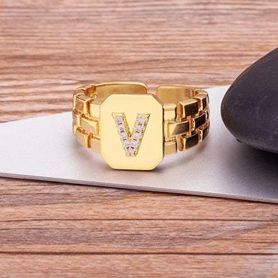 Gold chunky ring with embossed letter "V" and imitation gems.