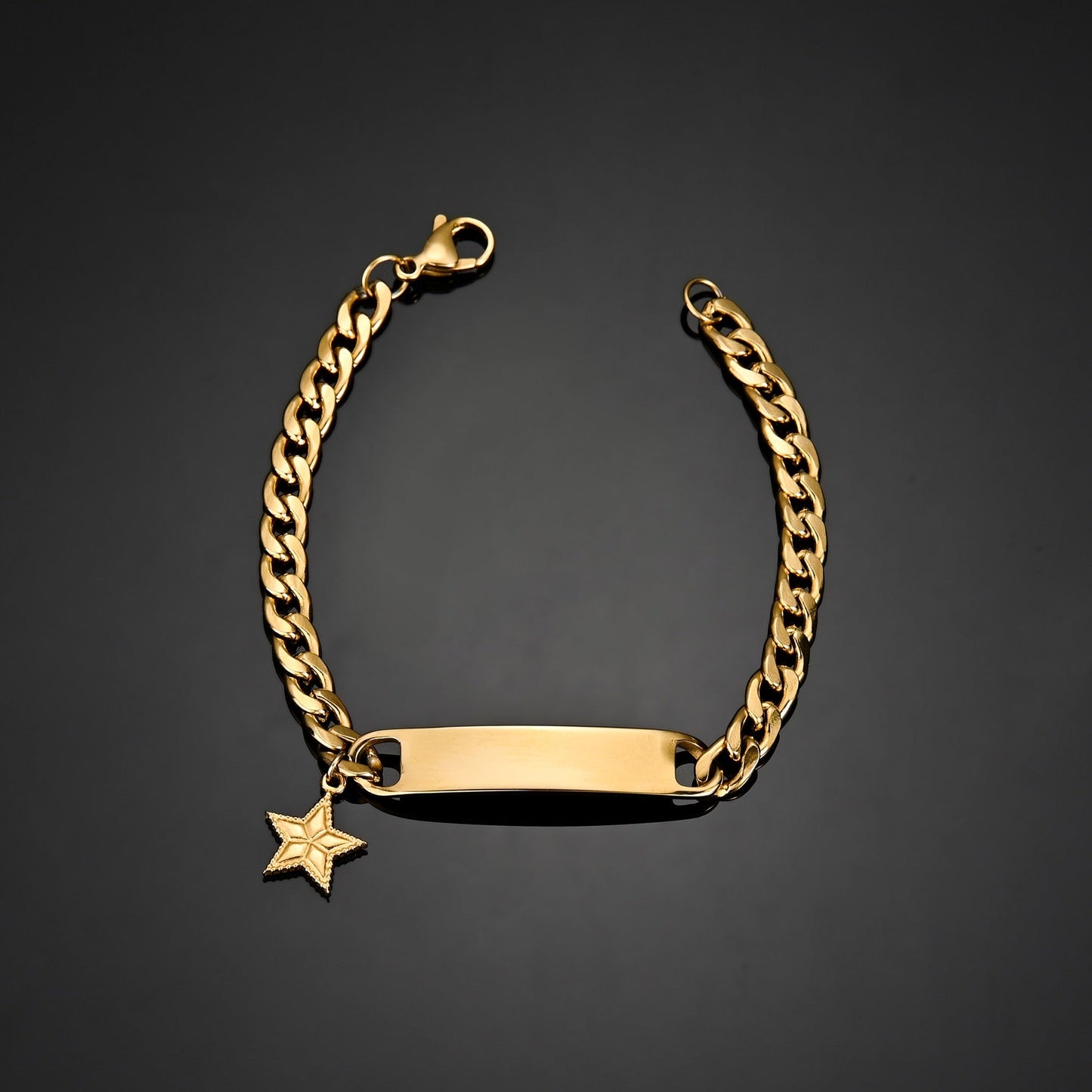 Engraved Nameplate Bracelet Cuban Chain with gold pendant on black background.