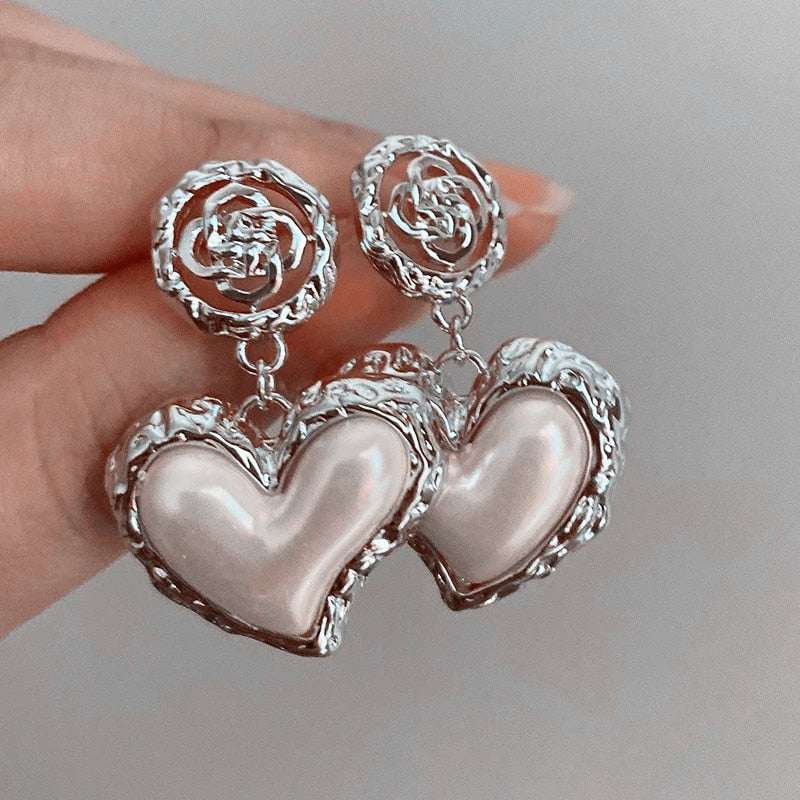 Warped Heart Earrings in silver and gold with an exquisite design.