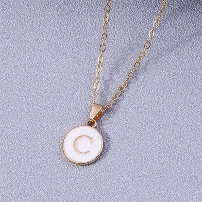 Custom letter white enamel circle necklace with gold detailing.