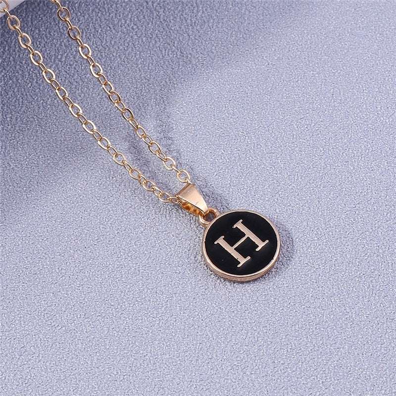 YourLetter black enamel initial necklace with gold chain.