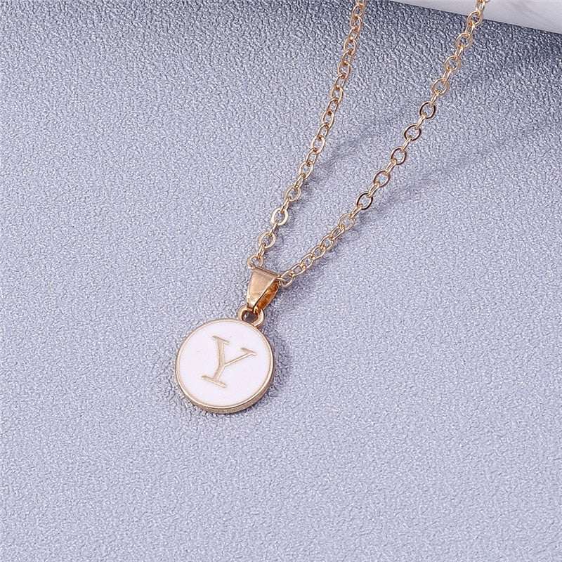 Customizable white enamel circle necklace with gold detailing and letter pendant.