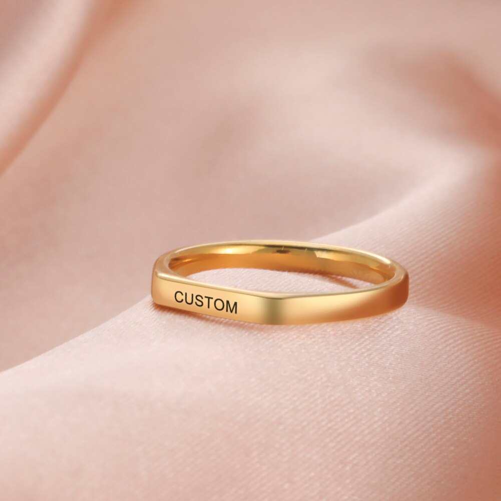 Engraved custom name flat band ring in gold finish.