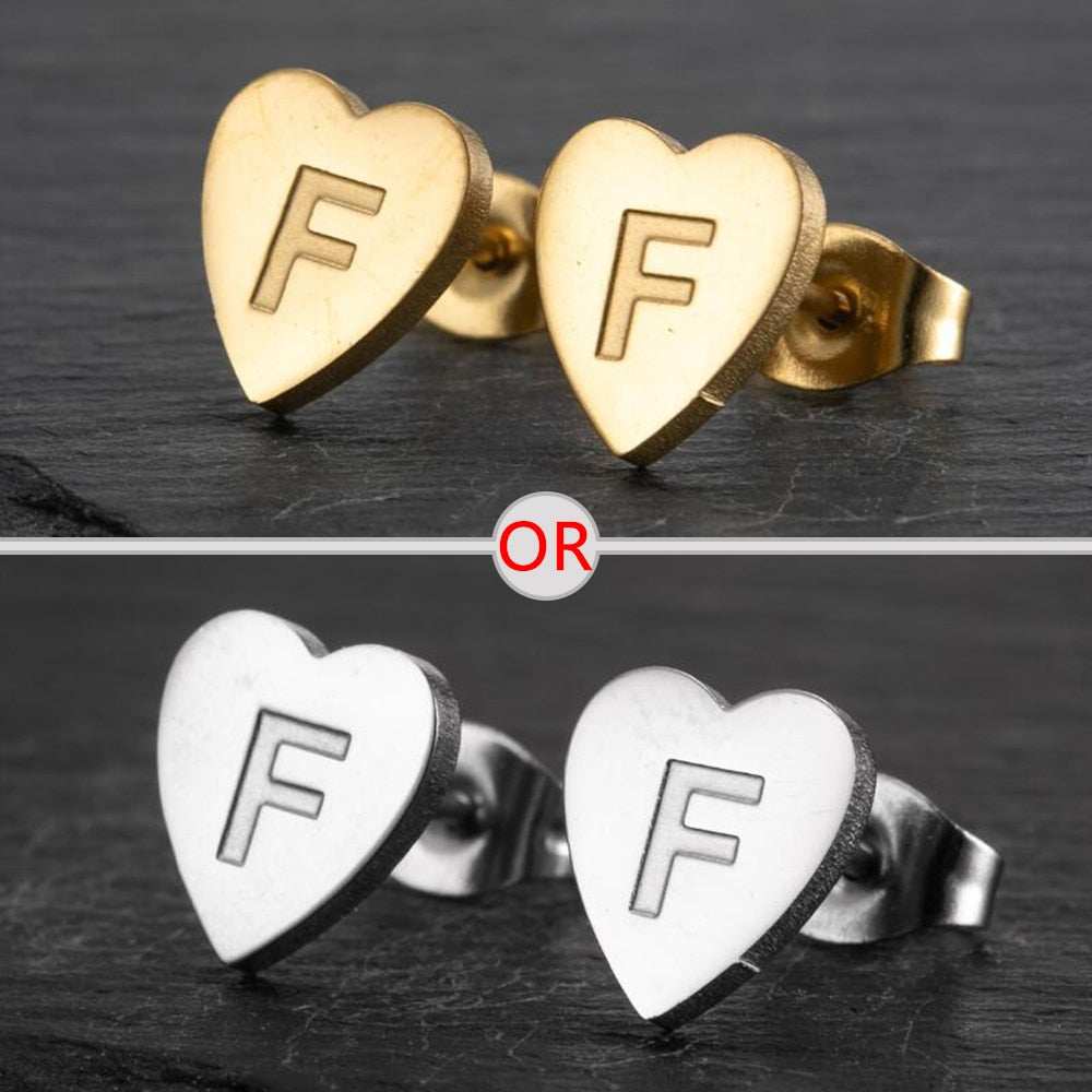 Heart-shaped stud earrings with a personalized initial in silver and gold finish.