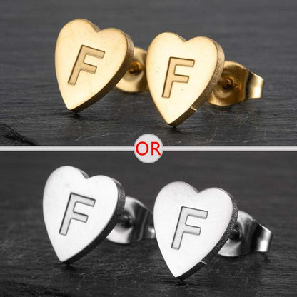 Heart-shaped stud earrings with a personalized initial in silver and gold finish.