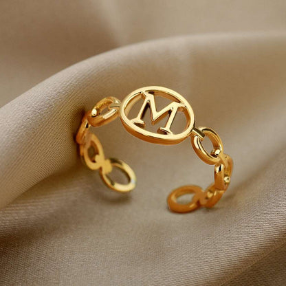 Hollow loop ring with customizable initial in gold, featuring a unique design and adjustable fit.