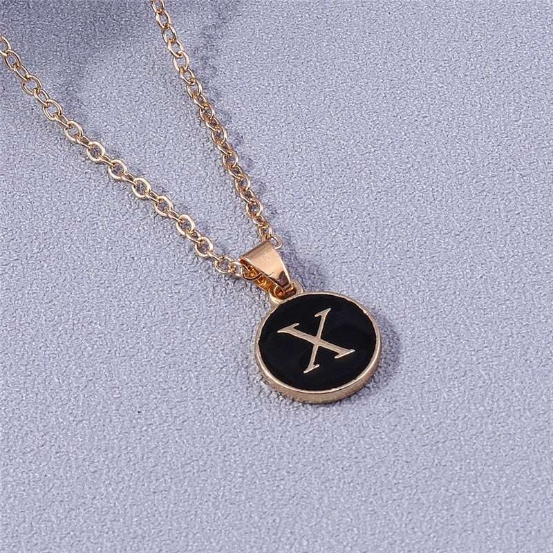 YourLetter Black Enamel Necklace with gold letter pendant on a chain.