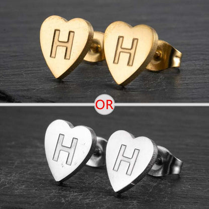 Heart-shaped stud earrings with personalized initial in silver and gold finish.