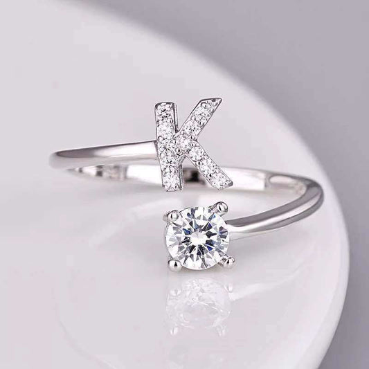 Letter K ring with gem stud on adjustable band in silver.